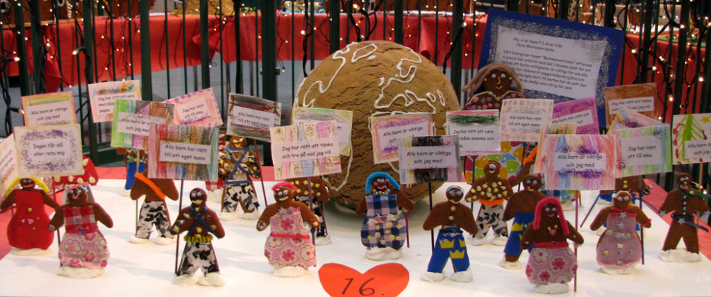 Pepparkakor håller upp skyltar. På skyltarna står budskap om barns rättigheter.  