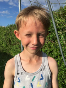 Rasmus kisar mot solen och ler.