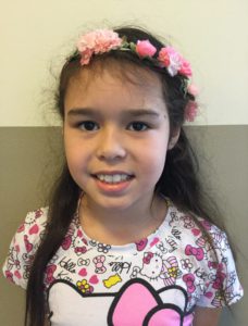 Sofie har en hello kitty-tröja och ett diadem med blommar i sitt långa svarta hår.