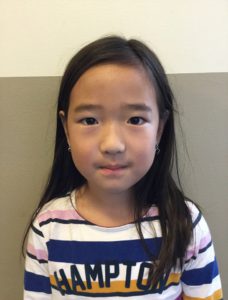 Wenjing. Hon har långt svart hår och en randig tröja.