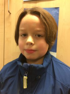 Gordon tittar in i kameran. Han har halvlångt brunt hår och blå tröja.