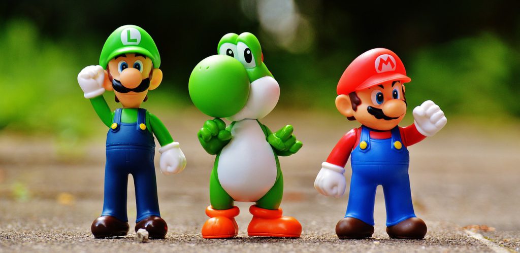 Tre leksakerfigurer som föreställer Luigi, Yoshi och Mario.
