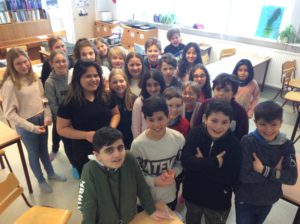 En gruppbild på barn som står i ett klassrum.