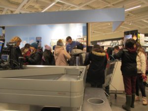 Flera barn står vid kassan i en butik.