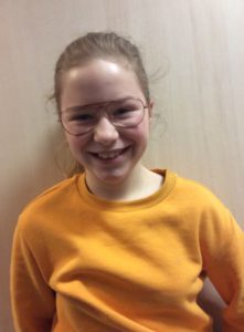 Bild på person men orange tröja och glasögon.