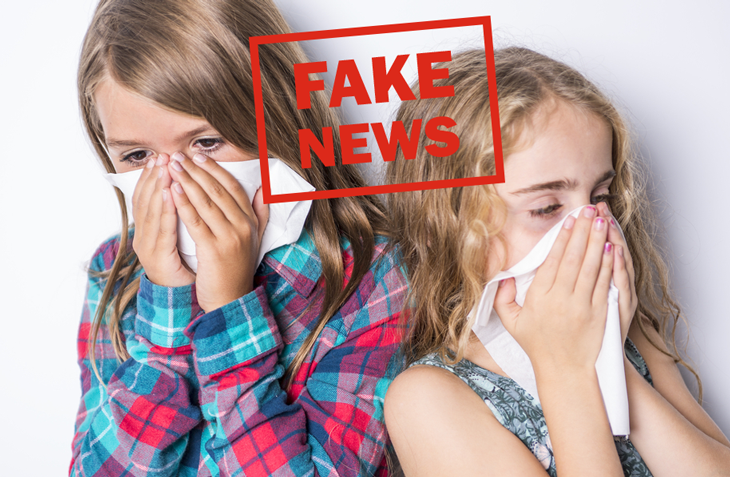 Två flickor som snyter sig och texten "Fake News" skriven med röda bokstäver.
