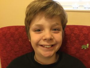 Ett porträttfoto på ett barn som ler.