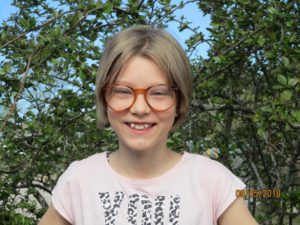 Nelli står framför en buske.