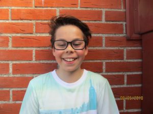 Edvin står mot en tegelvägg.