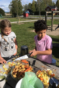 Samir Ahmed och Hanna Ekberg hackar grönsaker.