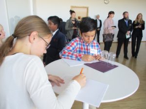 Minireportrar står vid ett bord och antecknar frågorna till prinsen.