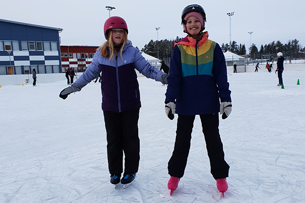 Elin och Alicia åker skridskor.