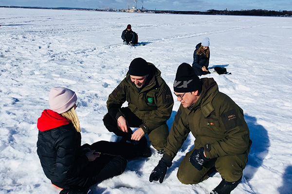 Stefan och Stefan assisterar Wilma Lundgren med pimpelfisket.