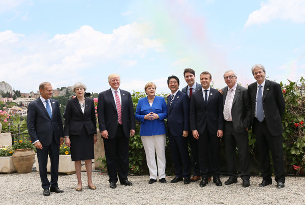 Flera av världens mest kända ledare står i en park. Några av ledarna är USA:s president Donald Trump och Frankrikes president Emmanuel Macron.