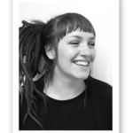 Jennie skrattar. Hon har lugg och stort långt hår med dreads.