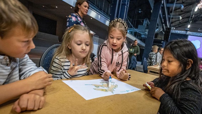 Fyra barn har samlats runt en teckning