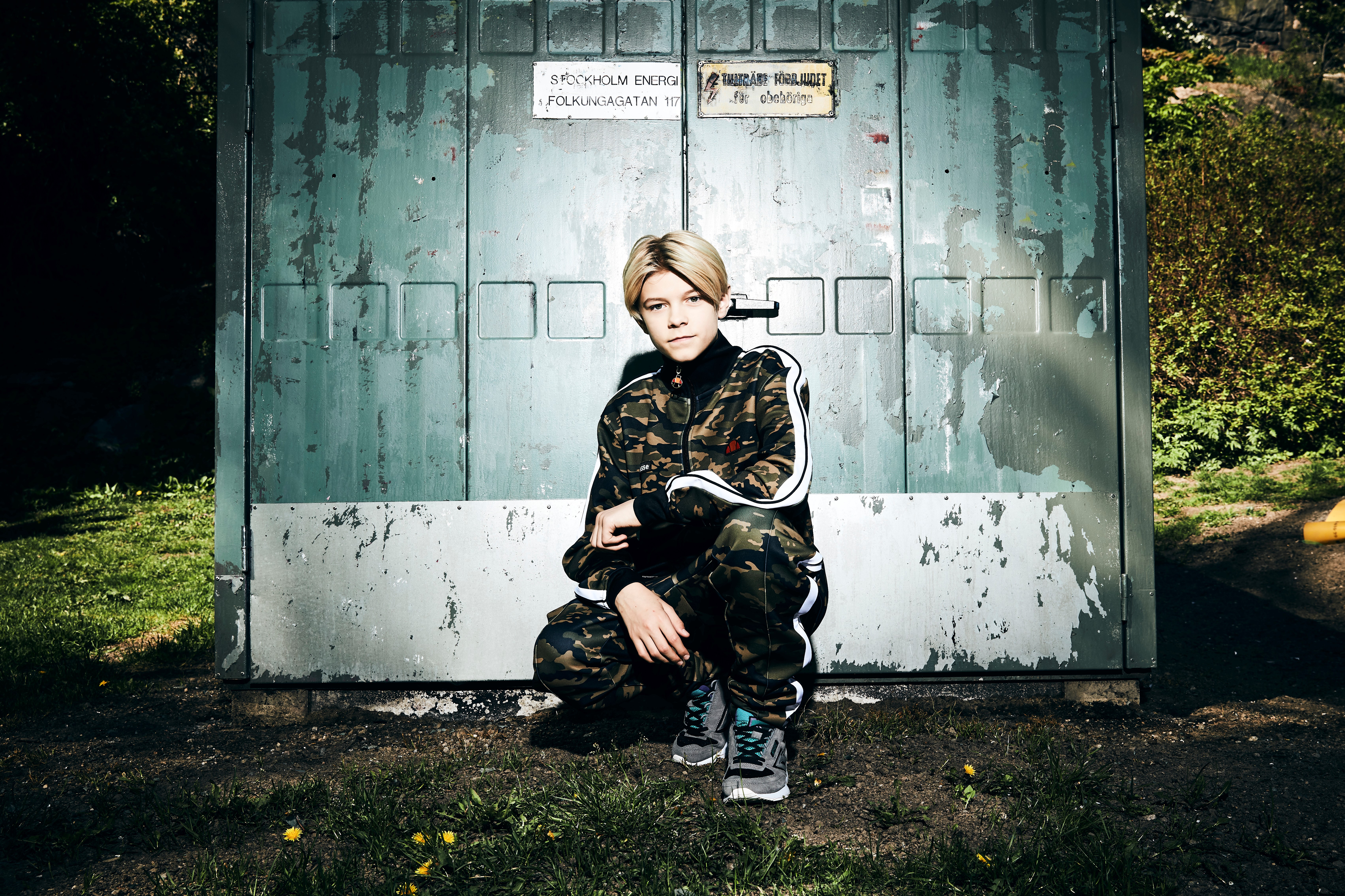 Theoz står på huk framför en container.