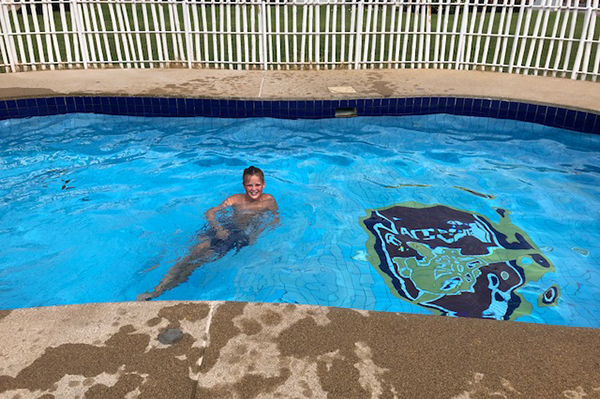 Oskar som badar i skolans pool.