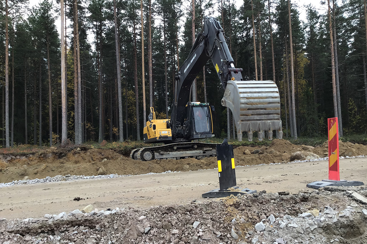 Foto på en gul grävmaskin med en stor tandskopa