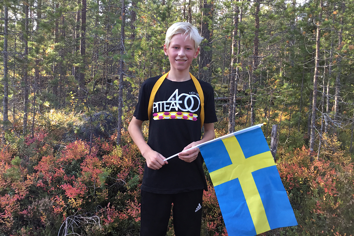 Porträtt på elev med en flagga i handen.