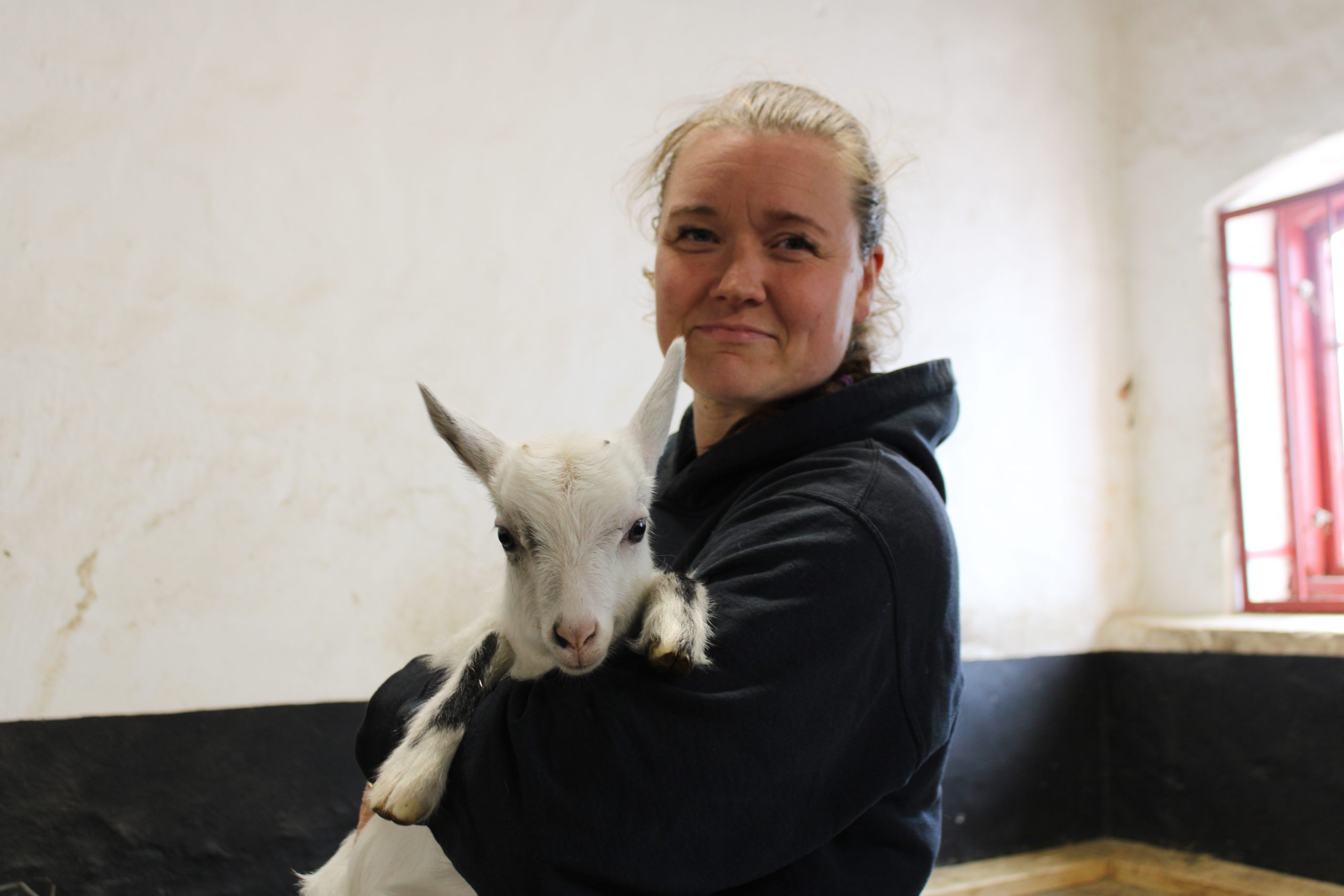 En kvinna håller en killing i famnen.